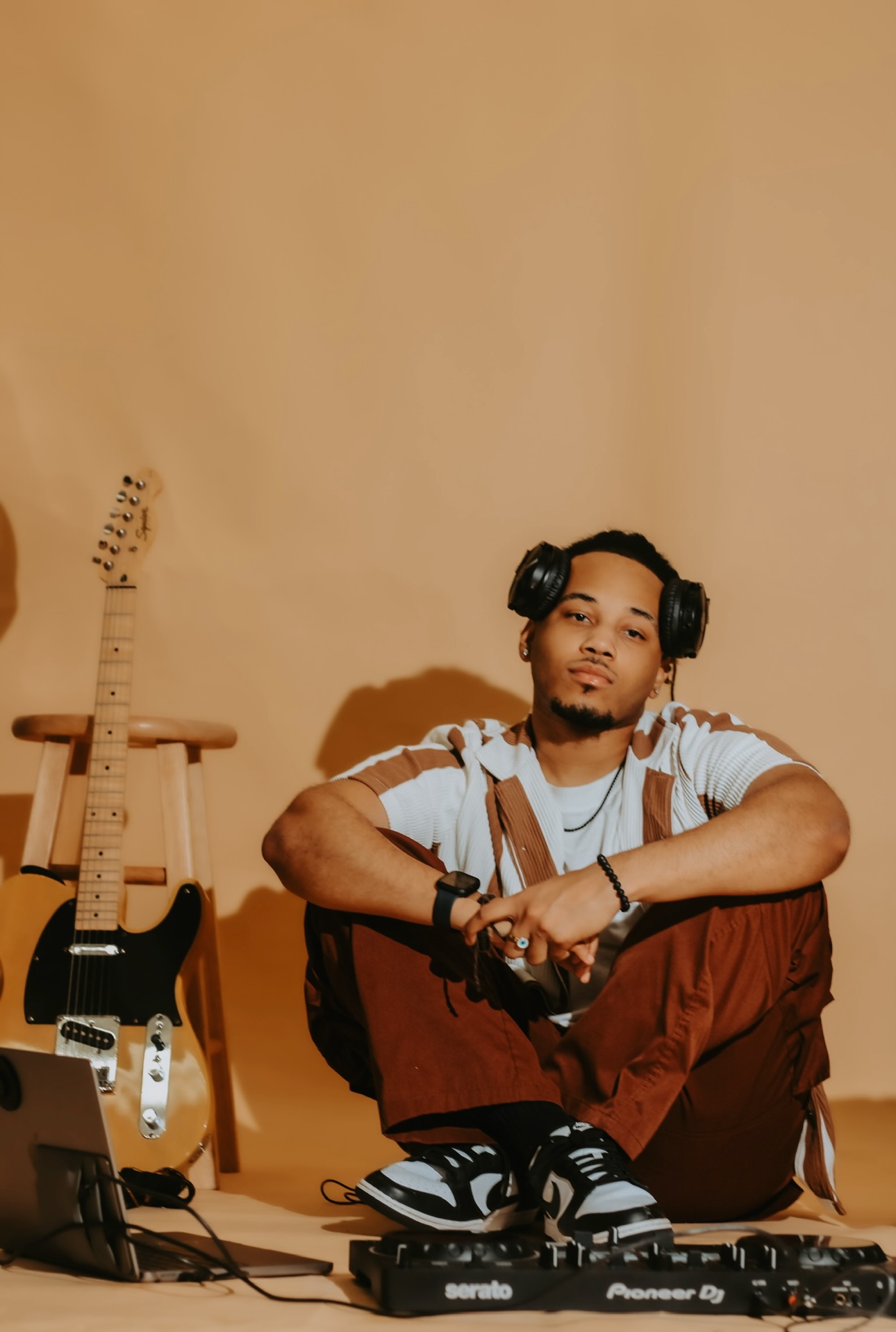 Tre Tensei portrait with headphones, guitar, and DJ controller